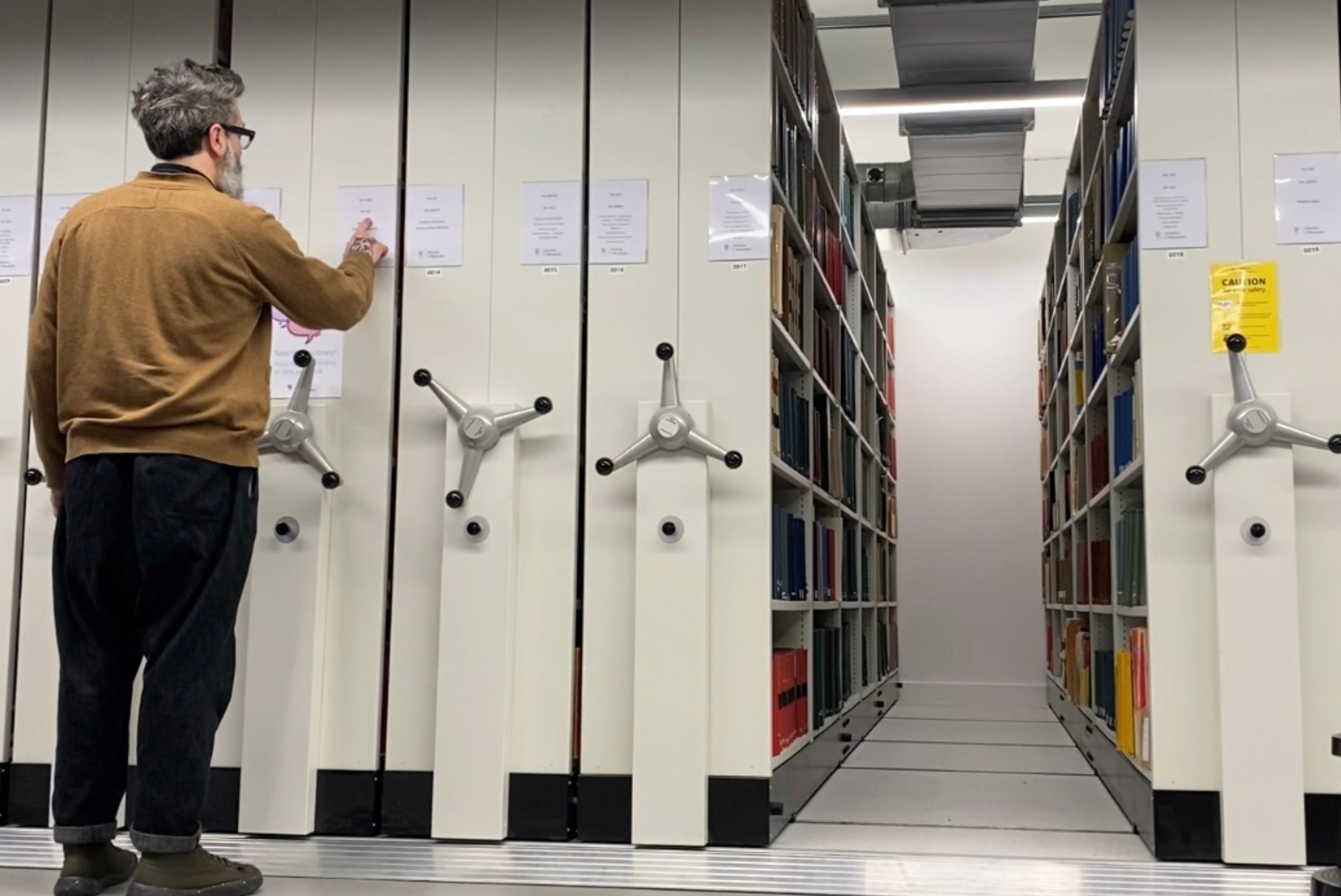 A man looks at the stacks in the WBH Reading Room